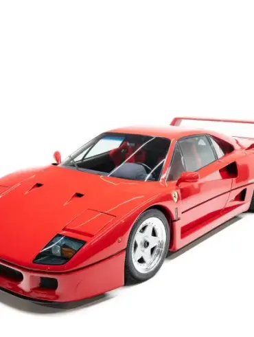 Ferrari F40 in Rosso Corsa, seitlich von vorne fotografiert vor weißem Hintergrund.