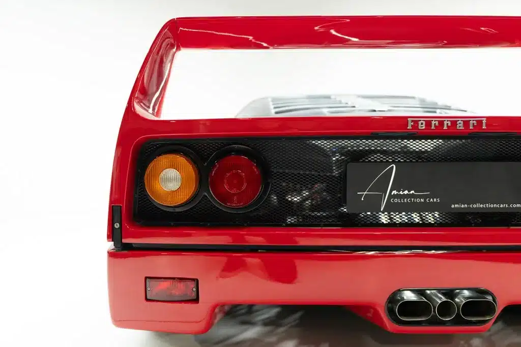 Nahaufnahme des Hecks eines Ferrari F40 in Rot mit großem Spoiler und Doppelendrohr.
