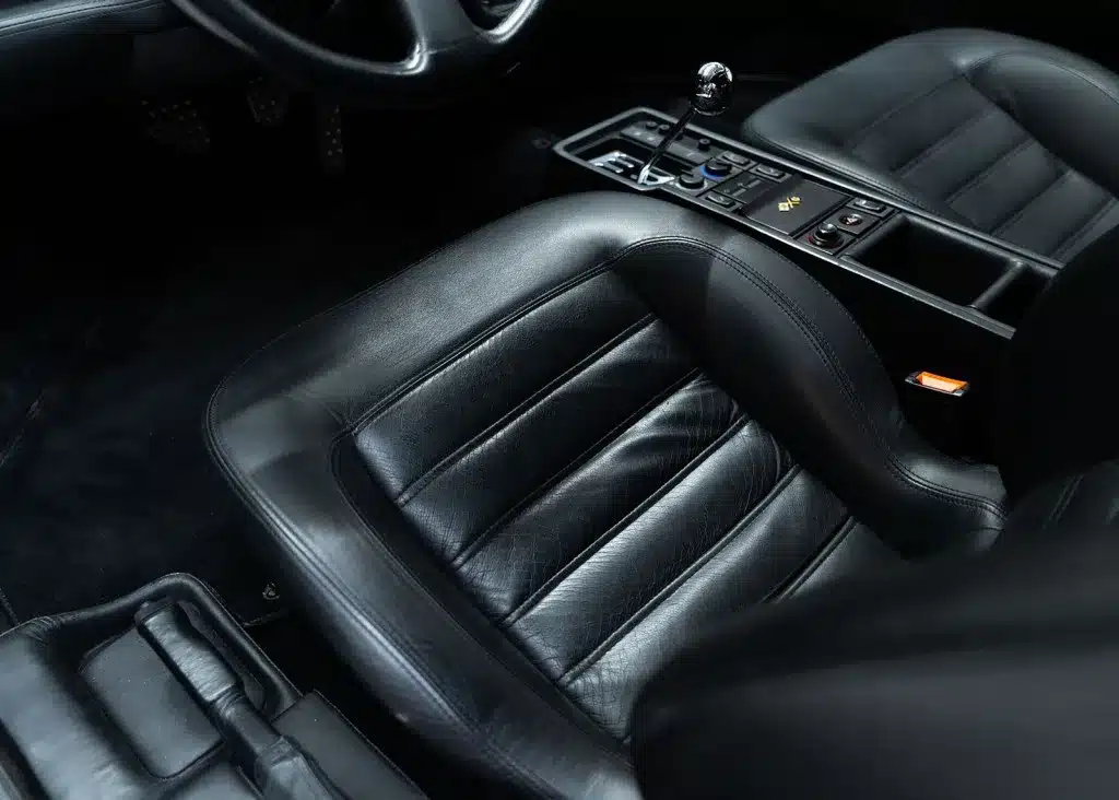 Ferrari F512 M Innenraum mit schwarzen Ledersitzen und manuellem Schaltgetriebe.