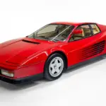 Ferrari Testarossa Monospecchio, rotes Coupé Baujahr 1986 mit einem Außenspiegel, seitliche Lamellen, Studioaufnahme.