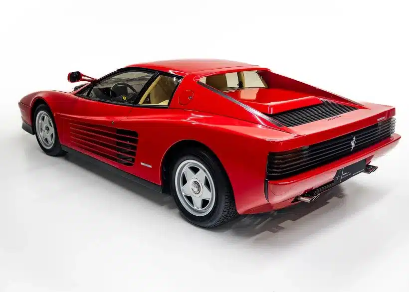 Roter Ferrari Testarossa Monospecchio von hinten links in einem Fotostudio, zeigt die ikonischen Lufteinlässe und die typische Coupé-Linie.