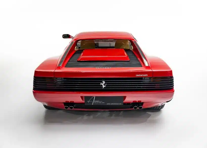 Heckansicht eines roten Ferrari Testarossa Monospecchio von 1986 mit horizontalen Lamellen und sichtbarem Ferrari-Logo auf weißem Hintergrund.