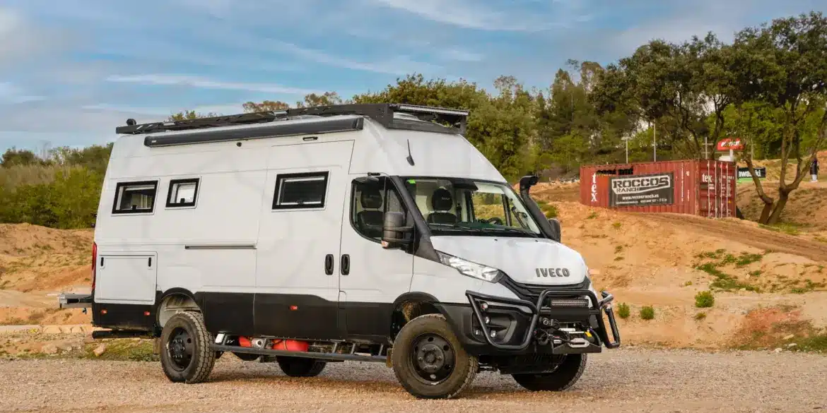 Seitlich aufgenommener Iveco Daily 4x4 L4H3 Expeditionscamper auf unbefestigtem Gelände mit Offroad- und Campingausstattung.