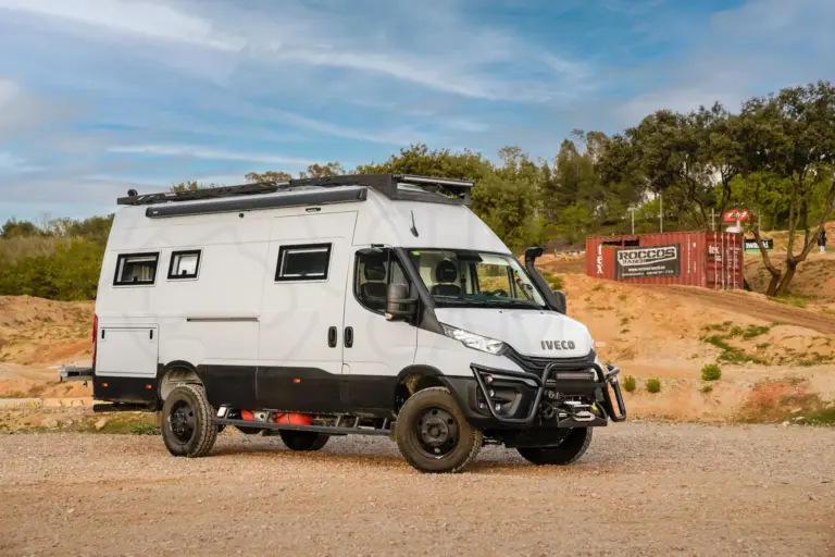 Seitlich aufgenommener Iveco Daily 4x4 L4H3 Expeditionscamper auf unbefestigtem Gelände mit Offroad- und Campingausstattung.