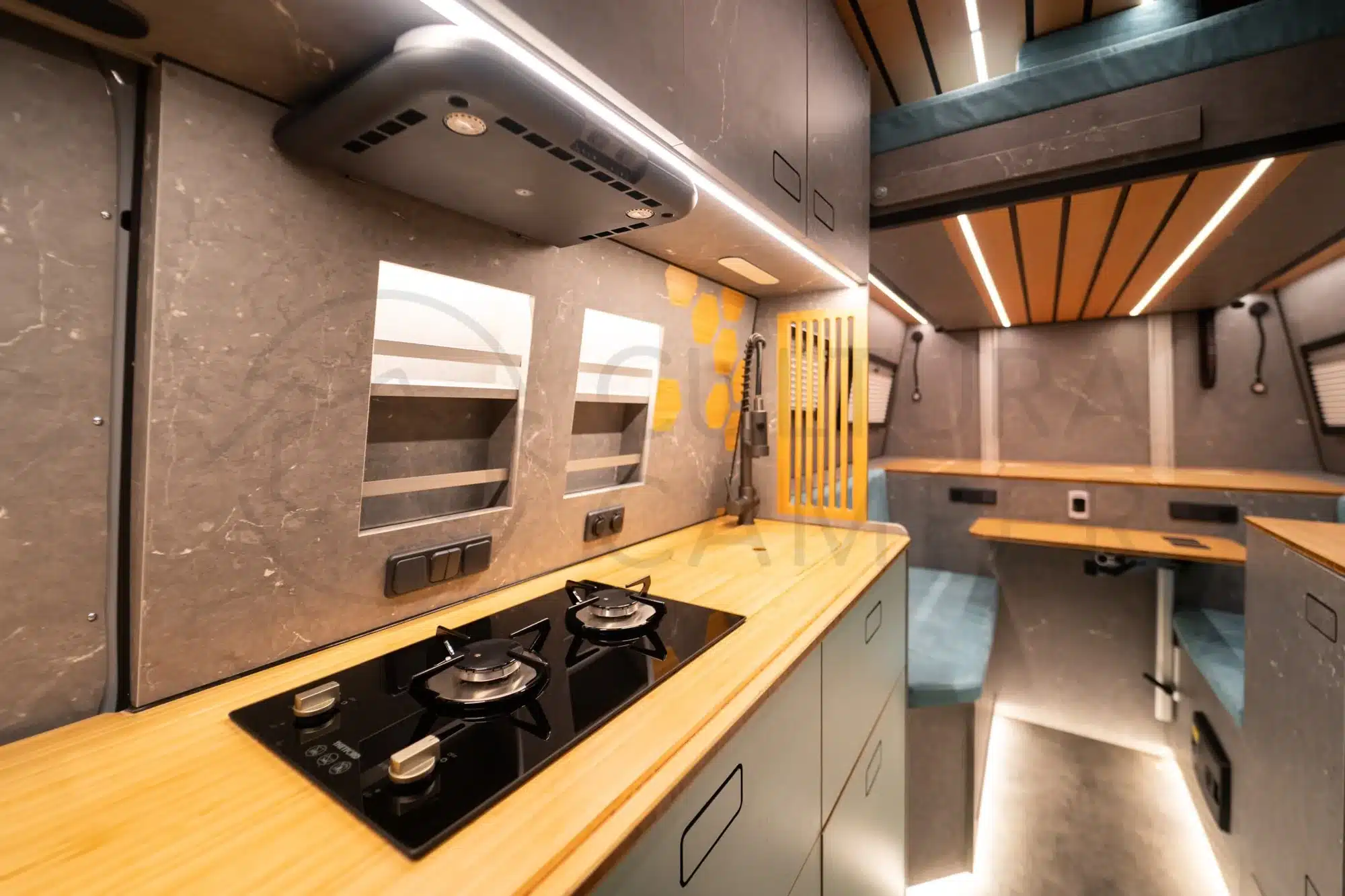 Blick in den hochwertig ausgebauten Innenraum eines Iveco Daily 4x4 mit moderner Küchenzeile und Sitzgruppe