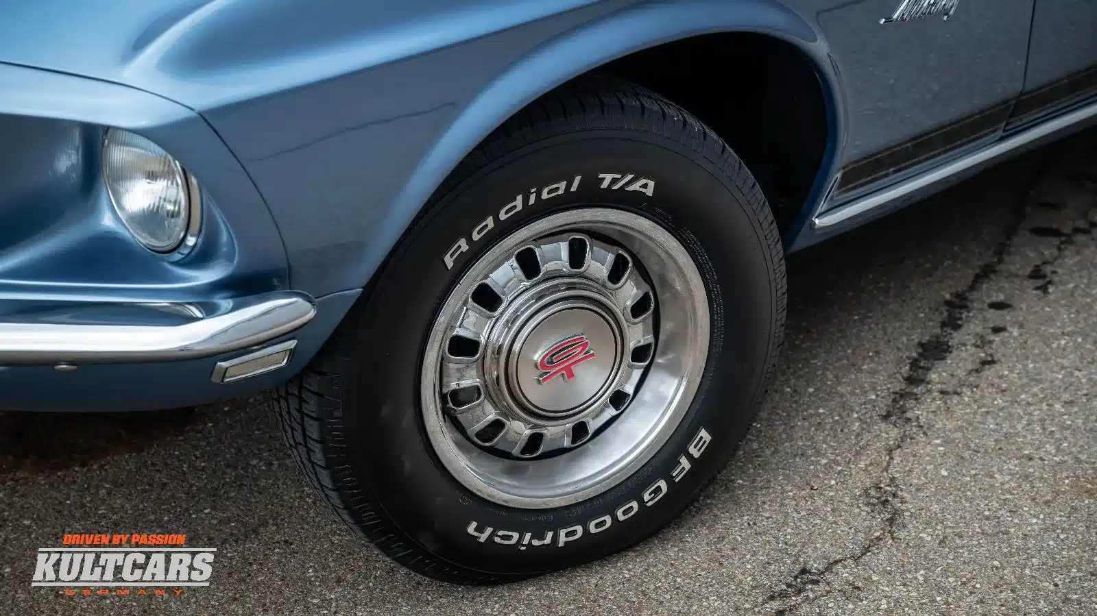 Vorderrad und Front eines blauen Ford Mustang 428 Cobra Jet Convertible, Baujahr 1969, mit GT-Radkappe und BF Goodrich Reifen