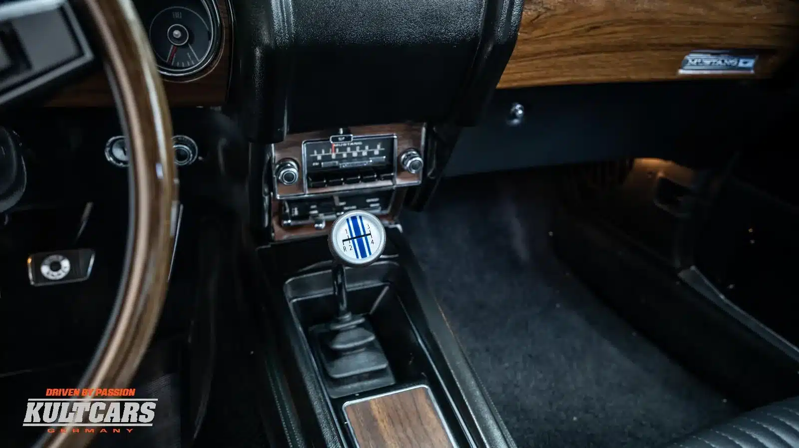 Schalthebel und Mittelkonsole eines restaurierten 1969er Ford Mustang 428 Cobra Jet Convertible mit Holzapplikationen und klassischem Armaturenbrett.