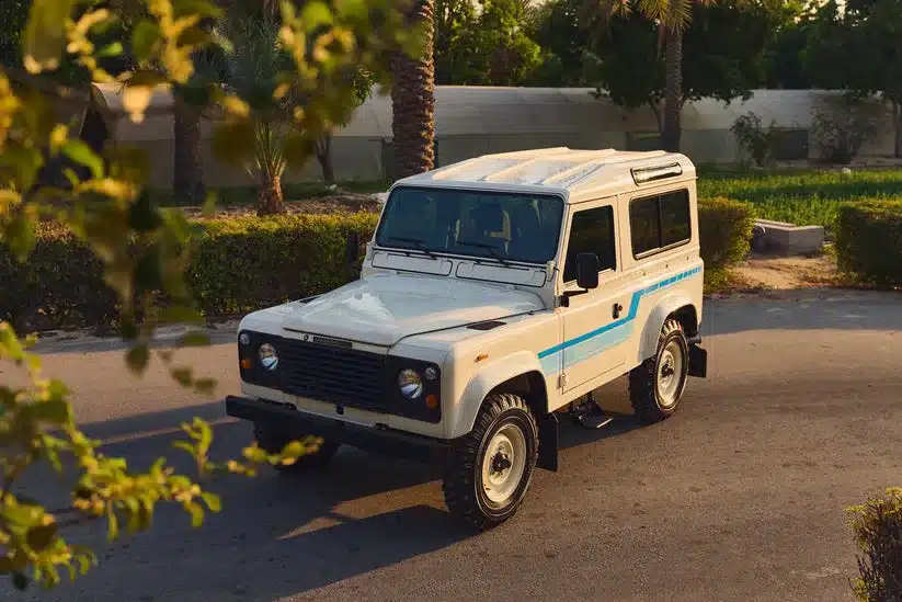 Land Rover 90 in Ivory White von 1985, im Sonnenschein auf einer ruhigen Straße geparkt, restaurierter Zustand