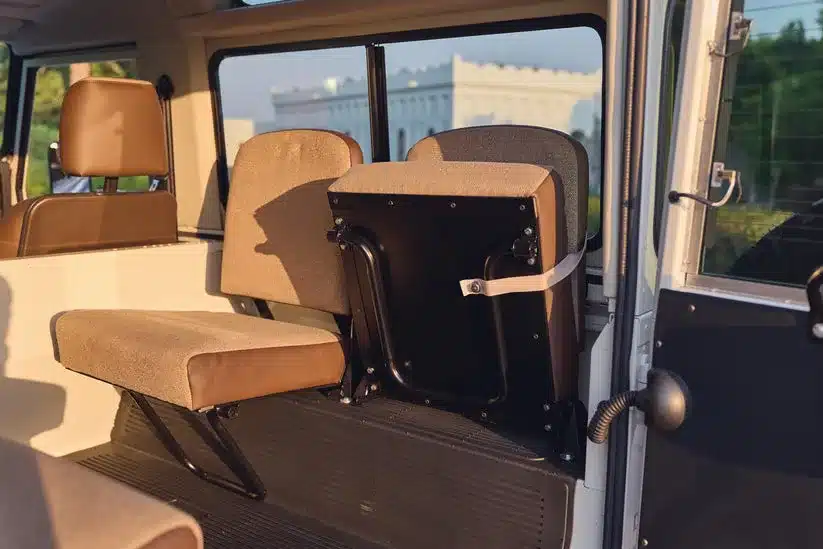 Innenraum eines Land Rover 90 aus dem Jahr 1985 mit hochgeklappten und heruntergeklappten Originalsitzen