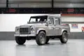 Veredelter Land Rover Defender 110 Double Cab von 2011 in Stornoway Grau, präsentiert in einer Halle.