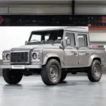 Veredelter Land Rover Defender 110 Double Cab von 2011 in Stornoway Grau, präsentiert in einer Halle.