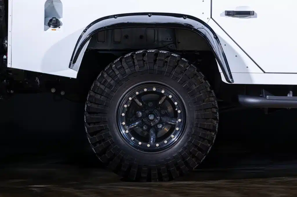 Radkasten und Offroad-Reifen eines weißen Land Rover Defender aus der Seitenansicht