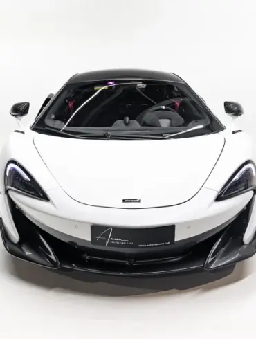 Frontansicht eines weißen McLaren 600LT Apex mit schwarzem Dach vor weißem Hintergrund.