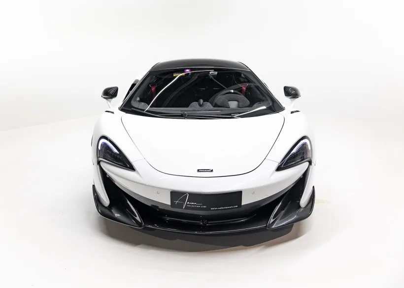 Frontansicht eines weißen McLaren 600LT Apex mit schwarzem Dach vor weißem Hintergrund.
