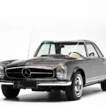 Mercedes-Benz 230 SL Pagode, Baujahr 1964, braun-bronzemetallic, mit Hardtop auf weißem Hintergrund