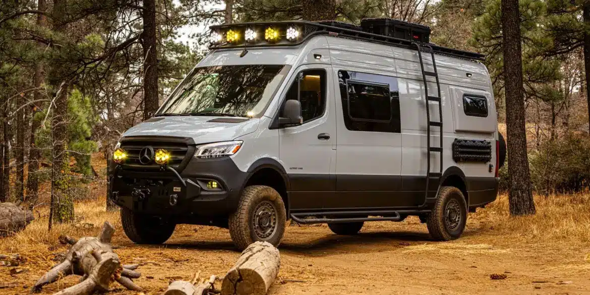 Mercedes-Benz Sprinter 170 High Roof Offroad-Ausbau 'Güero' mit Dachträger, Zusatzscheinwerfern und Expeditionsausstattung im Wald.