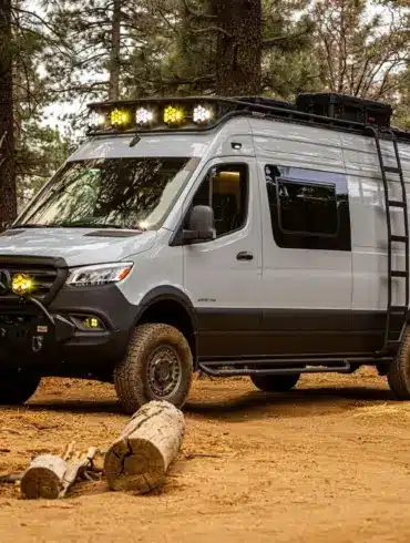 Mercedes-Benz Sprinter 170 High Roof Offroad-Ausbau 'Güero' mit Dachträger, Zusatzscheinwerfern und Expeditionsausstattung im Wald.