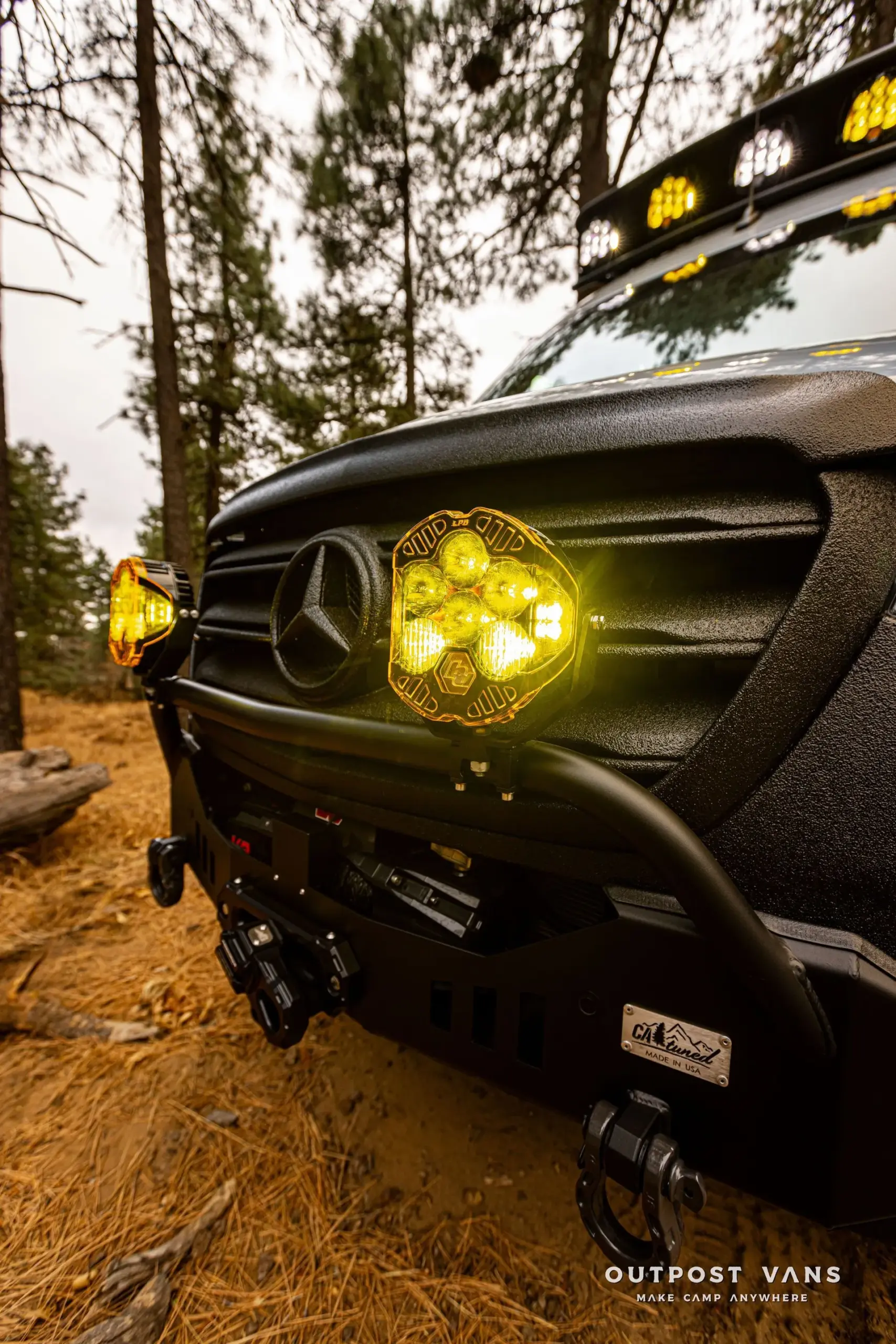 Offroad-Umbau eines Mercedes-Benz Sprinter mit Catuned-Stoßfänger, gelben Zusatzscheinwerfern und Seilwinde im Wald