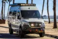 Mercedes Sprinter El Duque Expeditionsmobil mit Spezialausstattung am Strand vor Palmen.