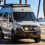 Mercedes Sprinter El Duque Expeditionsmobil mit Spezialausstattung am Strand vor Palmen.