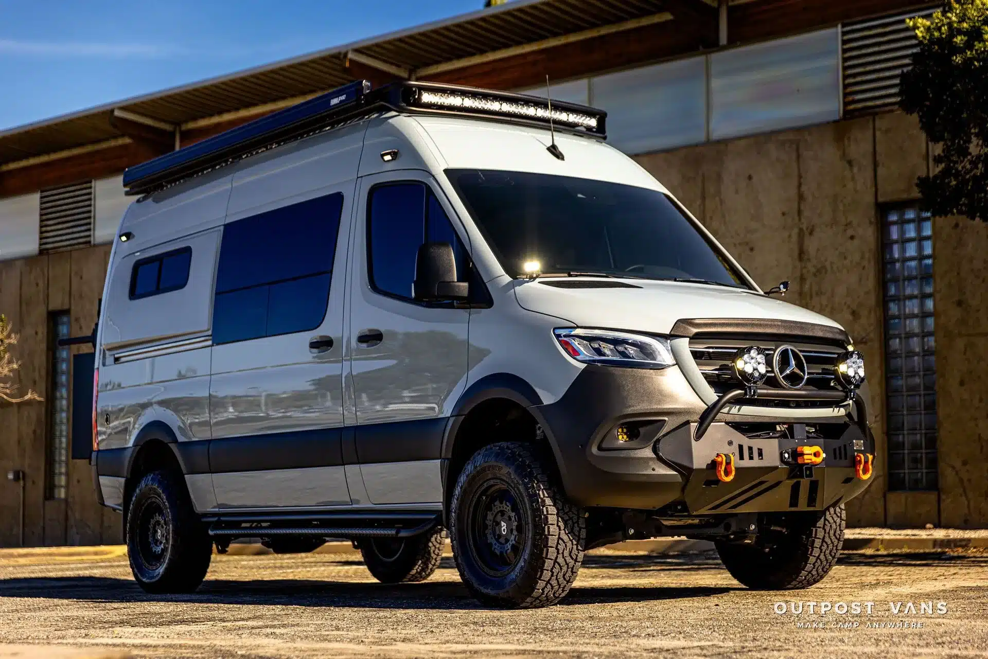 Seitenansicht des Mercedes-Benz Sprinter El Duque mit Offroad-Umbau, Dachträger und LED-Zusatzscheinwerfern im Sonnenlicht.