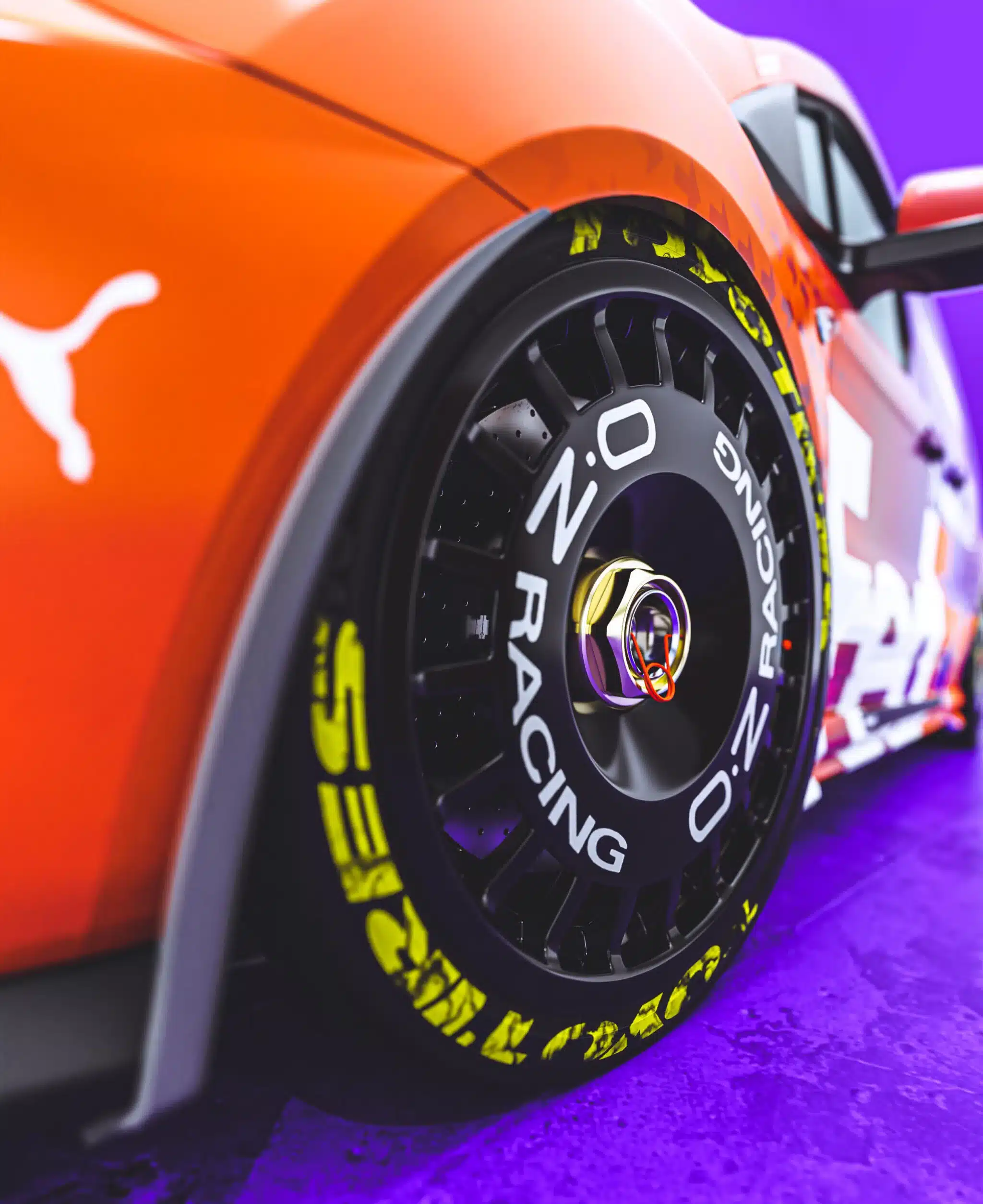 Nahaufnahme eines schwarzen OZ Racing Magnesiumrads mit Zentralverschluss und Toyo R888R Semi-Slick Reifen an einem sportlich umgebauten Ford Transit Connect MS-RT mit auffälliger Folierung.