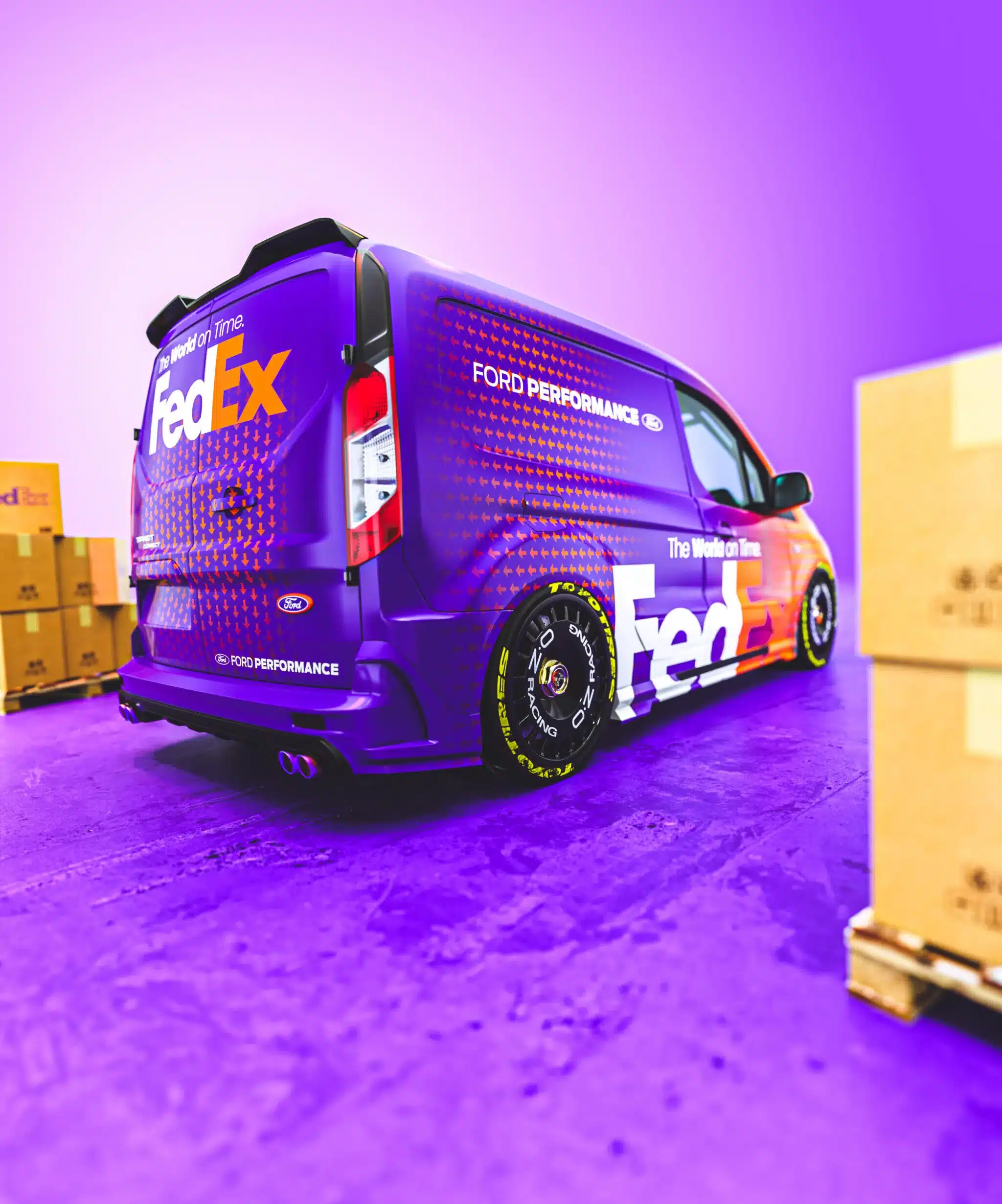 Ford Transit Connect MS-RT Custom im auffälligen FedEx-Tribute-Design mit sportlichen OZ Racing Rädern und Toyo R888R Reifen in einer Lagerhalle.
