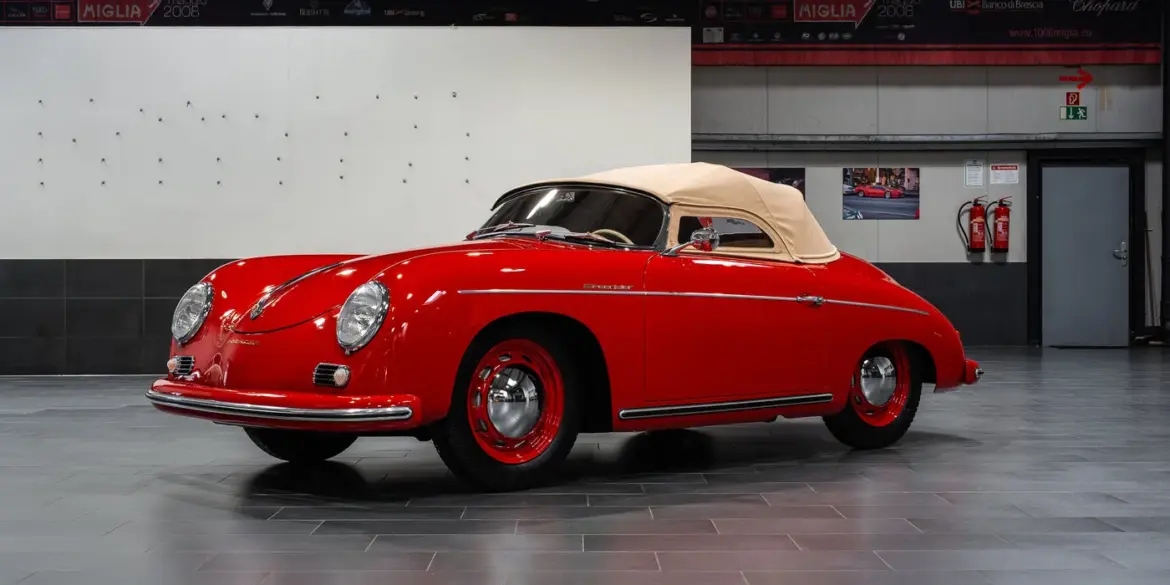 Restaurierter roter Porsche 356 Pre-A Speedster von 1955 mit beigem Verdeck in einer modernen Halle