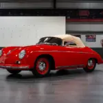 Restaurierter roter Porsche 356 Pre-A Speedster von 1955 mit beigem Verdeck in einer modernen Halle