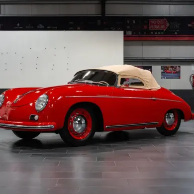 Restaurierter roter Porsche 356 Pre-A Speedster von 1955 mit beigem Verdeck in einer modernen Halle