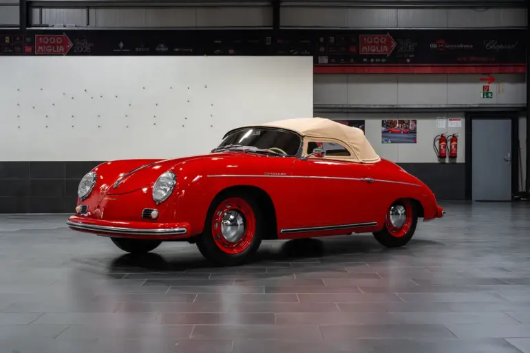 Restaurierter roter Porsche 356 Pre-A Speedster von 1955 mit beigem Verdeck in einer modernen Halle
