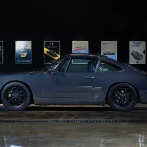 Dunkelgrauer Porsche 911 (964) Carrera 2, Baujahr 1991, mit schwarzen Felgen und grünen Akzenten, seitlich fotografiert in einer Ausstellungshalle