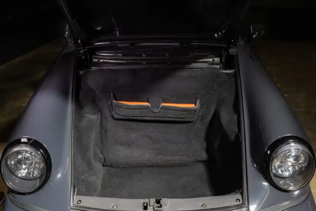 Offener vorderer Kofferraum eines Porsche 911 (964) Carrera 2 mit sauberer Auskleidung und Werkzeugtasche