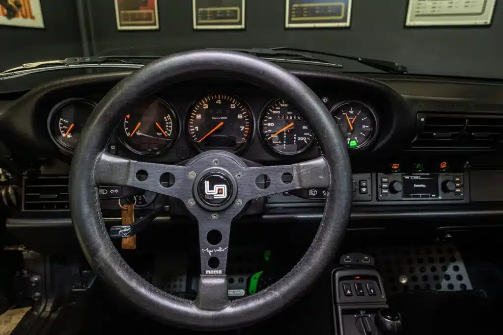 Cockpit und Lenkrad eines Porsche 911 (964) Carrera 2 mit sichtbaren Instrumenten und Momo-Lenkrad.