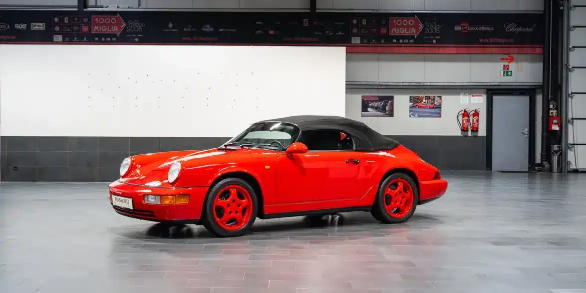 Porsche 911 (964) Carrera Speedster in Indischrot mit schwarzen RS-Schalensitzen und geschlossenem Verdeck, seitliche Ansicht.