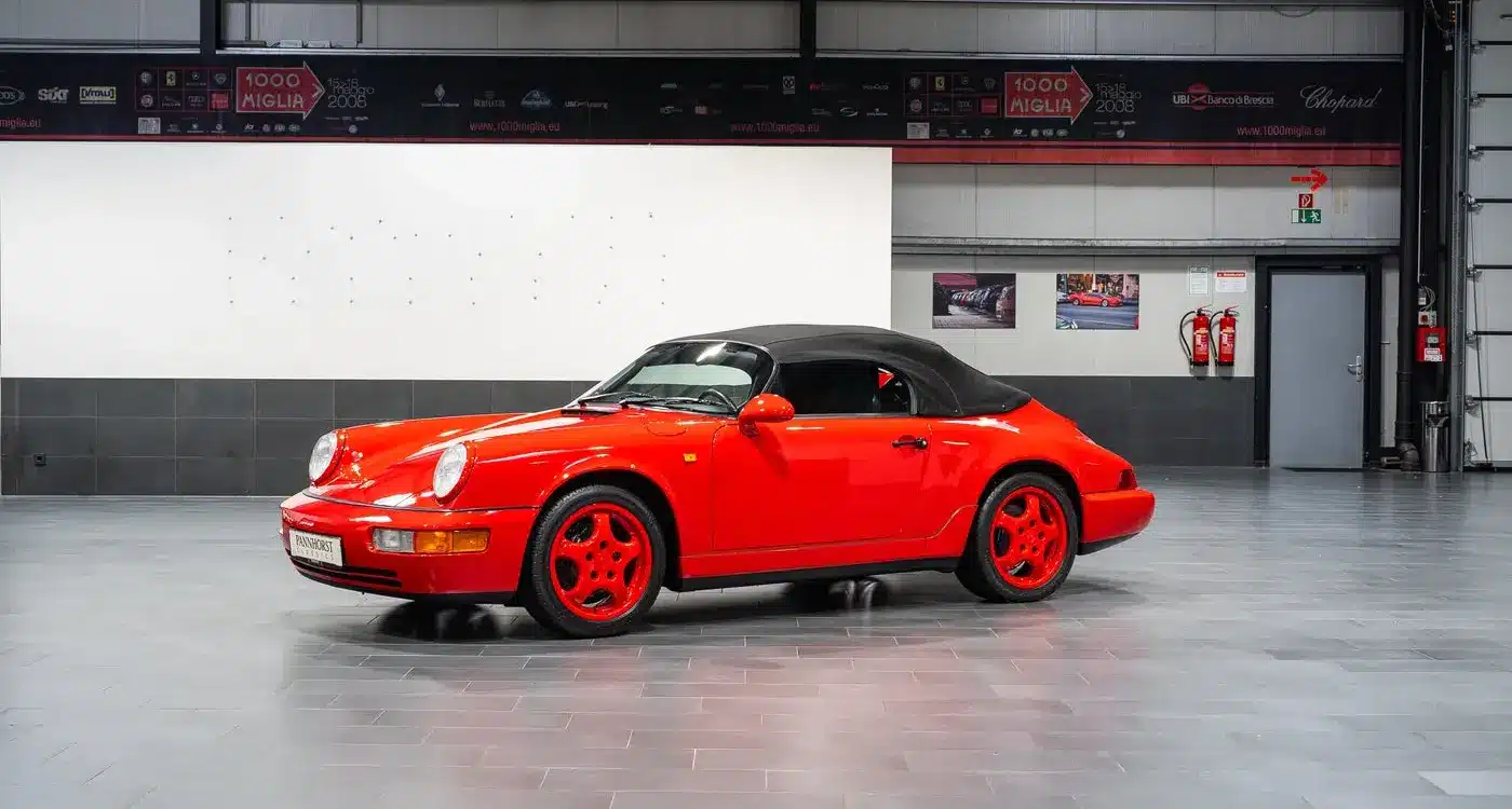 Porsche 911 (964) Carrera Speedster in Indischrot mit schwarzen RS-Schalensitzen und geschlossenem Verdeck, seitliche Ansicht.