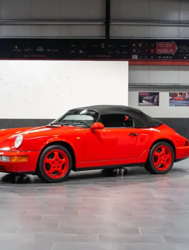 Porsche 911 (964) Carrera Speedster in Indischrot mit schwarzen RS-Schalensitzen und geschlossenem Verdeck, seitliche Ansicht.