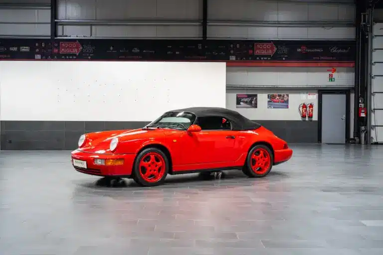 Porsche 911 (964) Carrera Speedster in Indischrot mit schwarzen RS-Schalensitzen und geschlossenem Verdeck, seitliche Ansicht.