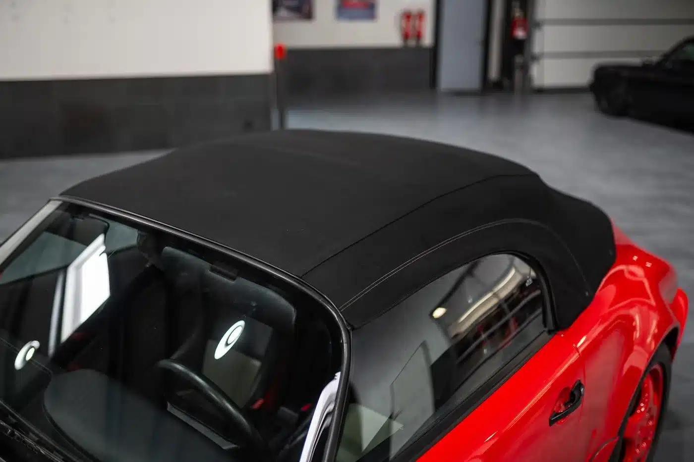 Das schwarze Stoffverdeck eines Porsche 911 (964) Carrera Speedster in Indischrot, fotografiert in einer Halle