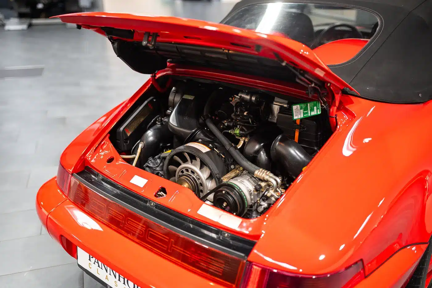 Geöffneter Motorraum eines roten Porsche 911 (964) Carrera Speedster mit sichtbarem Sechszylinder-Boxermotor.