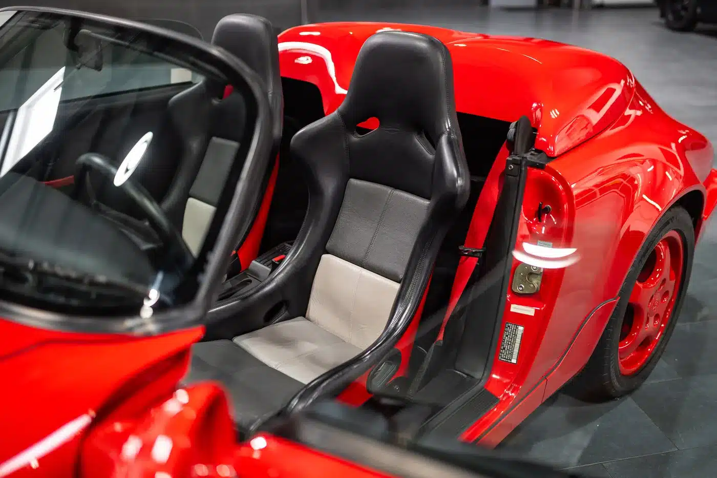RS-Schalensitze und Innenraum eines roten Porsche 911 (964) Carrera Speedster, Fokus auf sportliche Sitze und Türbereich.