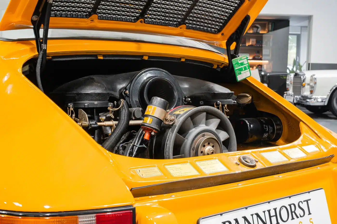 Blick auf den geöffneten Motorraum eines gelben Porsche 911 mit sichtbarem luftgekühltem Boxermotor