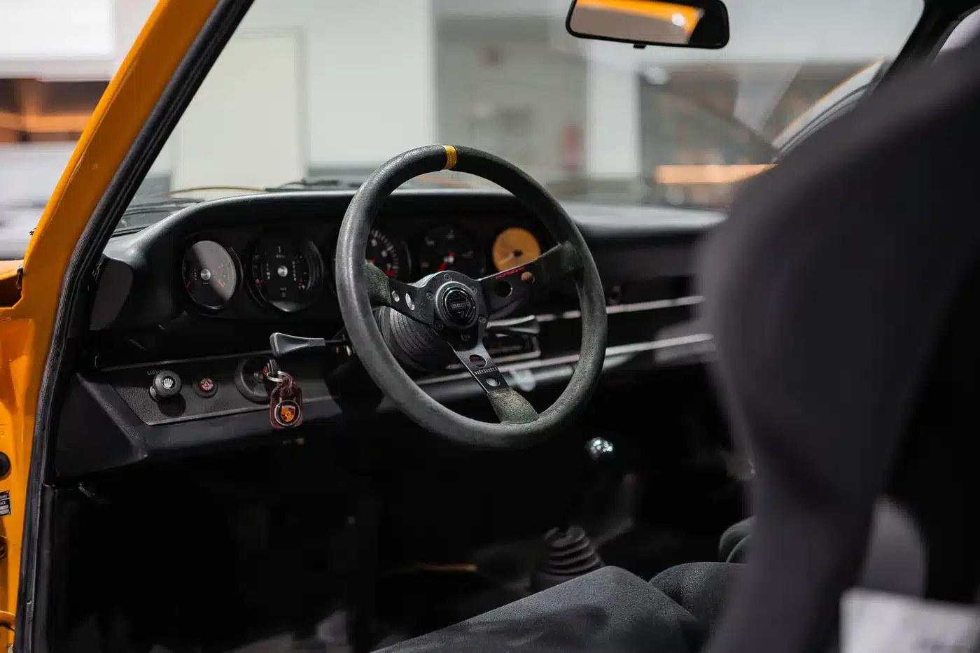 Innenraum eines klassischen Porsche 911 mit Momo-Lenkrad und typischen Rundinstrumenten