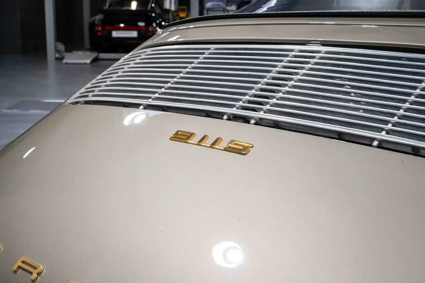 Detailaufnahme des Heckbereichs eines Porsche 911 S Softwindow Targa mit S-Emblem und lackierter Motorabdeckung in Mittelgrau Metallic.