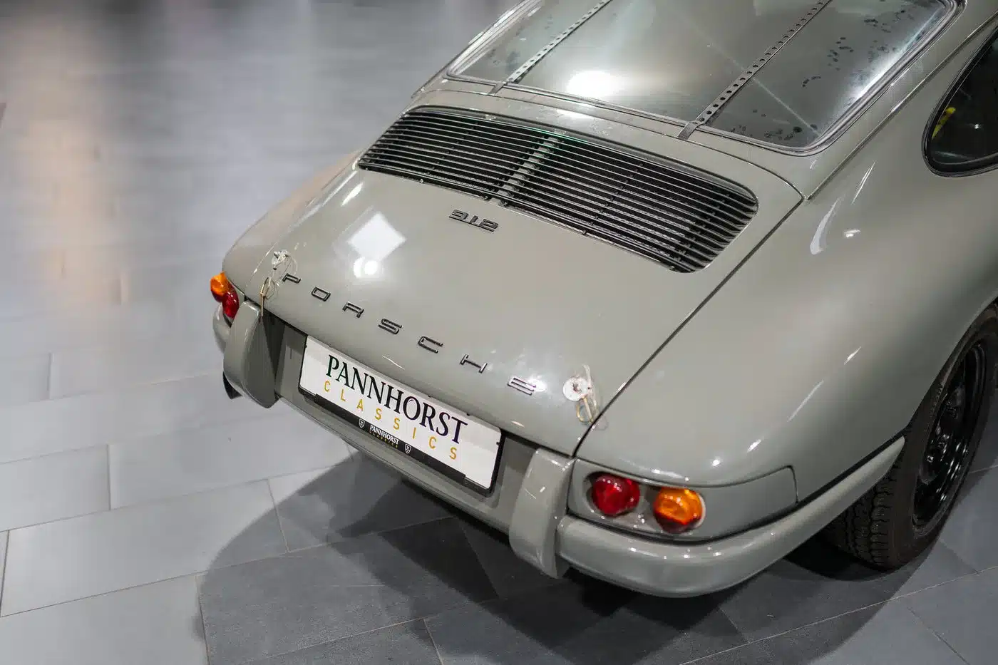 Heck eines Porsche 912 Coupé in Zeltgrau, Baujahr 1966, Motorsportausführung, aufgenommen in einer Ausstellungshalle.
