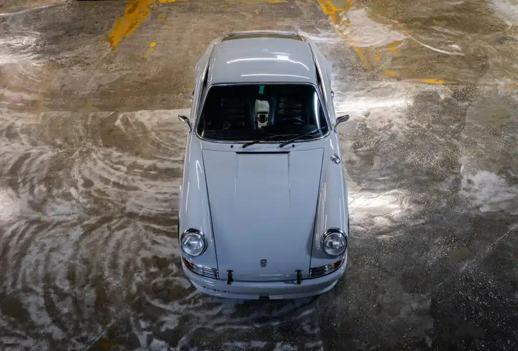 Silberner Porsche 964 C2 Backdate von oben fotografiert, stehend in einer Parkgarage.