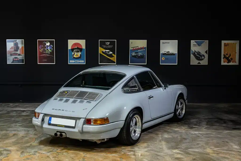 Porsche 964 C2 Backdate mit klassischer Langhauben-Silhouette von hinten vor Wand mit Automobil-Postern