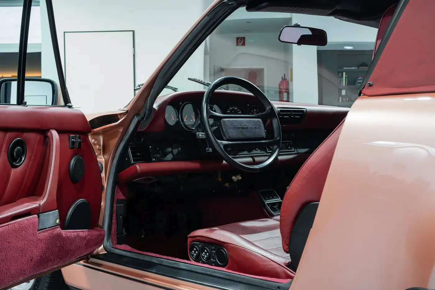 Blick in den Innenraum eines Porsche 964 Carrera 4 Cabriolet mit rotem Leder und offenem Verdeck