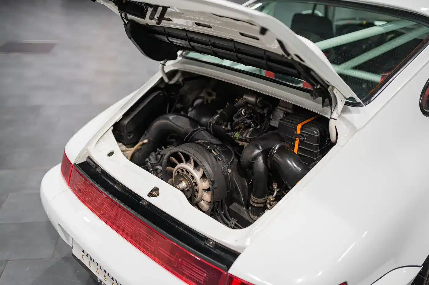 Der geöffnete Motorraum eines weißen Porsche 964 Carrera Cup von 1993 mit dem originalen 3,6-Liter-Boxermotor.