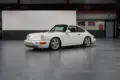 Weißer Porsche 964 RS steht in einer Hallengarage, Fahrerseite sichtbar